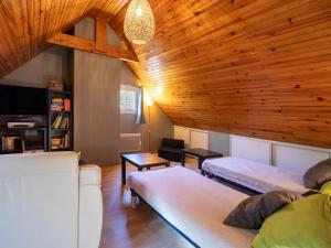 a living room with two beds and a wooden ceiling at Gite Au pied du Pic du Midi in Campan