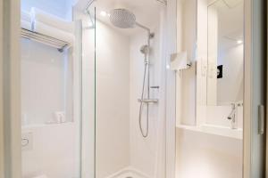 a bathroom with a shower with a glass door at Hôtel Eiffel Turenne in Paris