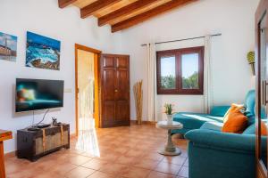 a living room with a blue couch and a tv at Can Pota in Portocolom
