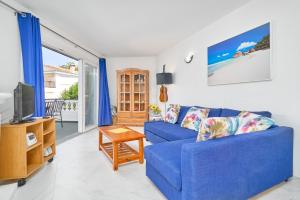 a living room with a blue couch and a tv at Casa Alina in Nerja