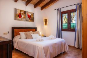 a bedroom with a bed with white sheets and a window at Can Pota in Portocolom +16 photos