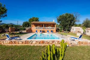 a villa with a swimming pool and two chairs at Can Pota in Portocolom