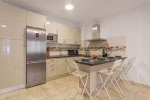 a kitchen with a refrigerator and a table with chairs at Apartamento Rolycar 201 in Icod de los Vinos