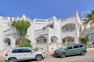 two cars parked in front of a white building at Casa Alina in Nerja
