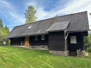 a black house with a grass yard in front of it at Lorenzfranzl in Sankt Oswald ob Eibiswald