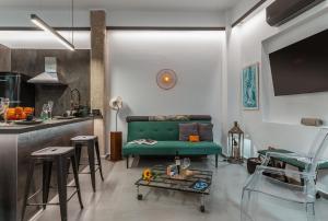 a living room with a green couch and a kitchen at Artrock Experience Loft Gallery in Ermoupoli