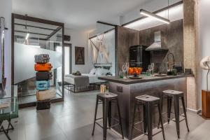 a kitchen with a counter and stools in a room at Artrock Experience Loft Gallery in Ermoupoli