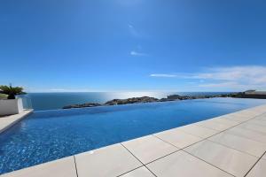 a swimming pool with the ocean in the background at Blue infinity 7 in Cumbre del Sol
