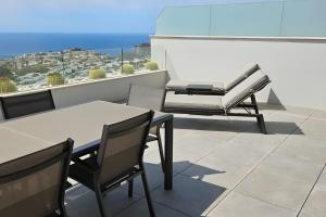 a patio with a table and chairs on a balcony at Blue infinity 7 in Cumbre del Sol