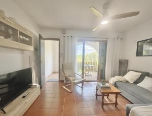 a living room with a couch and a tv at Costa Arenal 5 in Arenal d'en Castell