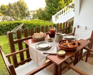 a wooden table with a bowl of food on a patio at Costa Arenal 5 in Arenal d'en Castell