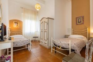 a bedroom with two beds and a desk at Piccolo Paradiso - Montenero in Montenero