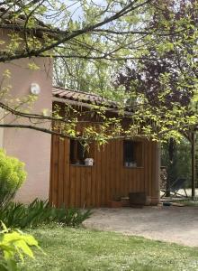 a house with a wooden fence and a yard at Petit nid pour oiseaux de passage in Cayriech