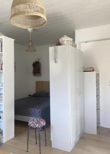 a bedroom with a bed and a stool and a chandelier at Petit nid pour oiseaux de passage in Cayriech