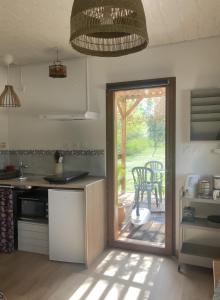 a kitchen with a sliding glass door leading to a patio at Petit nid pour oiseaux de passage in Cayriech