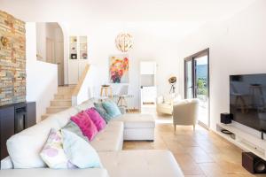 a living room with a white couch and a tv at Casa Vista Del Mar in Calonge