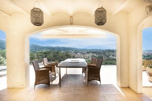 a dining room with a table and chairs on a patio at Casa Vista Del Mar in Calonge