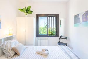 a white bedroom with a bed and a chair at Casa Vista Del Mar in Calonge +22 photos