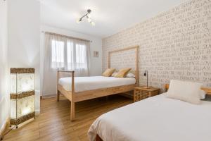 a bedroom with two beds and a window at Villa del Relax in Corralejo +36 photos