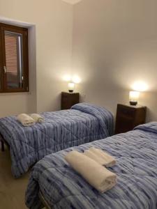 a bedroom with two beds with towels on them at Il Focolare dei Sibillini in Visso