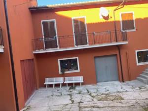 a building with two benches in front of it at Il Focolare dei Sibillini in Visso +3 photos