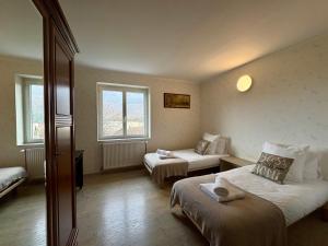a hotel room with two beds and two windows at Maison Des 3 Vallées - Wifi Véranda in Montmélian
