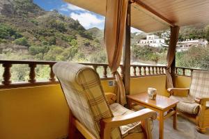 a balcony with chairs and a table and a view of a mountain at Casa Irene in Teror