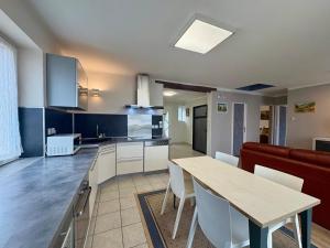 a kitchen and living room with a table and a couch at Maison Des 3 Vallées - Wifi Véranda in Montmélian