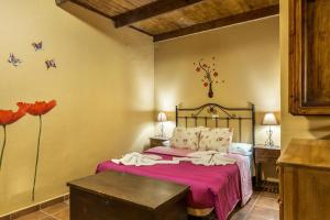 a bedroom with a bed with pink sheets and flowers at Casa Irene in Teror