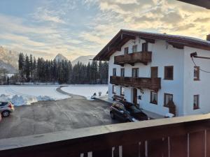 a building with a car parked in a parking lot at Ferienwohnung Hinterpommern - Chiemgaukarte in Inzell
