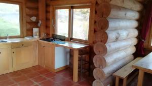 a kitchen in a log cabin with a counter and window at Le Chalet Neige in Chorges