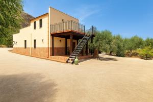 a house with a staircase on the side of it at Villa Gheta At The Monte Cofano in Custonaci