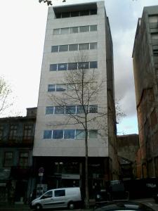 una furgoneta blanca estacionada frente a un edificio alto en Metro-Apartment RNAL nº35375 AL-Chamada para a rede móvel nacional, en Oporto