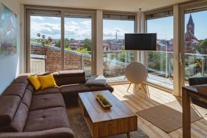 a living room with a couch and a large window at Penthouse Am Meer Barth in Barth +7 photos