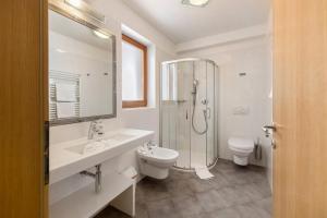 a bathroom with a sink and a toilet and a shower at Obertrisaierhof Wohnung 4 in Fie allo Sciliar +16 photos