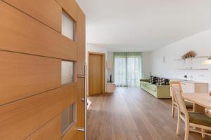 a kitchen and a living room with a wooden door at Obertrisaierhof Wohnung 4 in Fie allo Sciliar