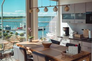 a kitchen with a table and a view of the water at Penthouse Am Meer Barth in Barth