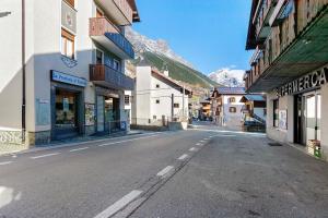 an empty street in a town with mountains in the background at Appartamento Via Livigno in Isolaccia