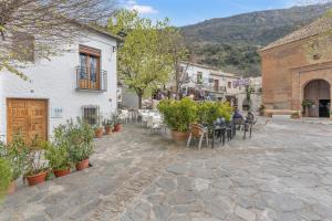 a courtyard with tables and chairs and a building at Casa Pepa in Pampaneira