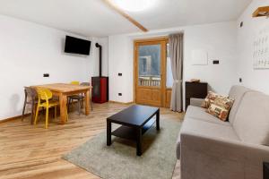 a living room with a couch and a table at Appartamento Via Livigno in Isolaccia