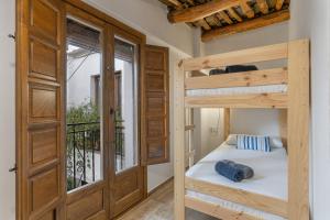 a bedroom with two bunk beds and a balcony at Casa Pepa in Pampaneira