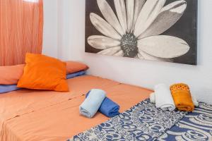 a bed with colorful pillows and a painting on the wall at Moby Dick in Benidorm +17 photos