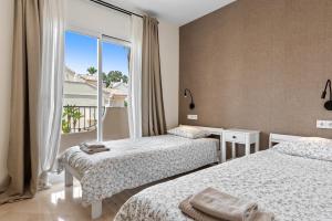 a bedroom with two beds and a large window at Casa Sunshine in Marbella +37 photos