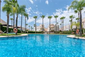 a large swimming pool with palm trees in the background at Casa Sunshine in Marbella