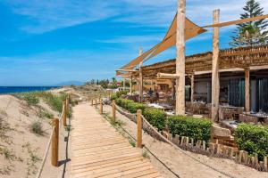 a wooden walkway to a restaurant on the beach at Casa Sunshine in Marbella