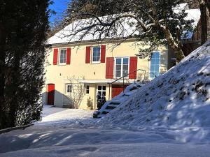 a house with red shutters in the snow at Haus Haselmaus - Buntspecht in Schwäbisch Gmünd