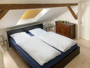 a bedroom with a large bed with white sheets at Haus Haselmaus - Buntspecht in Schwäbisch Gmünd