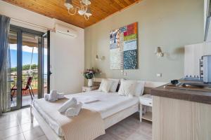 a living room with a bed and a balcony at Nontas Home 33 in Kalamitsi +18 photos