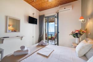 a bedroom with a large white bed with a view of the ocean at Nontas Home 33 in Kalamitsi