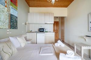 a living room with a white bed and a kitchen at Nontas Home 33 in Kalamitsi